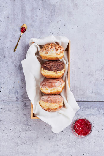 moderne foodfotografie verschiedener Krapfen auf weißem tuch auf beton untergrund, fotograf ines häberlein, regensburg, nürnberg, landshut, ingolstadt, produktfotografie,