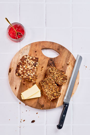 tabletop foodfotografie körnerbrot auf Holzbrett auf weißen Fliesenuntergrund fotograf ines häberlein, regensburg, nürnberg, landshut, ingolstadt, produktfotografie, Content creation
