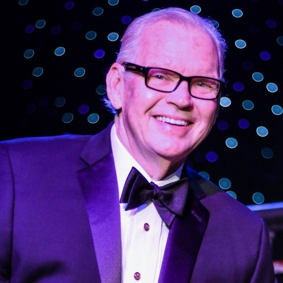 Jimmy Maxwell, a white male wearing a tuxedo and glasses, smiling and looking dapper