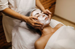 woman-beauty-salon-having-face-massage-with-cream-mask