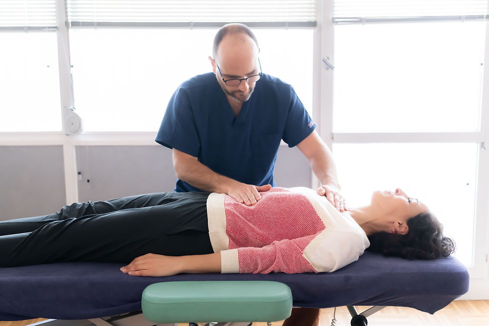 Ostéopathe pratiquant une technique abdominale douce sur une patiente allongée à Oullins.