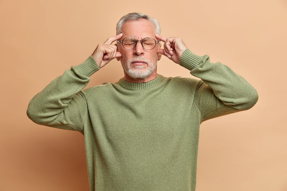 Homme aux yeux fermés tenant ses tempes, illustrant une sensation de vertige et d’instabilité.