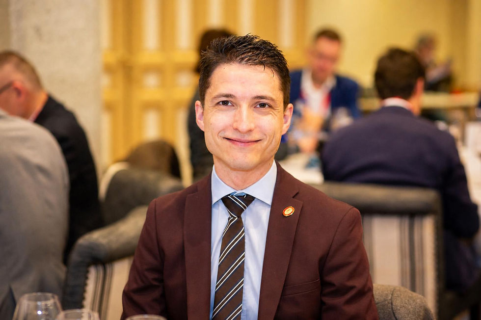 Tony Lécuroux MS, in a international wine challenge, sitting on a chair with a pleasant sniling face, ready to test wine