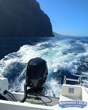 Primer plano de la carcasa negra del motor fueraborda Tohatsu acelerando y dejando una gran estela de espuma blanca en el Atlántico con Windward Catch Fishing Charter.