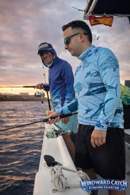 Pescadores equipados con ropa técnica manejando sus cañas de pescar al amanecer.