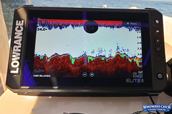 Vista de cerca del monitor de navegación y buscador de peces Lowrance instalado en la consola de mandos de Windward Catch Fishing Charter.