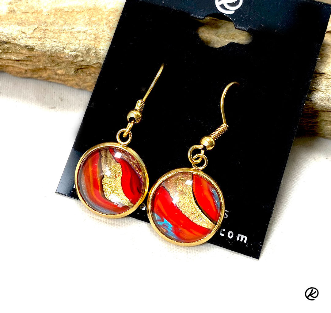 Red and gold poured acrylic art set into surgical steel