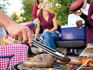 Bratwurst or Sausage On The Grill At Tailgate Party