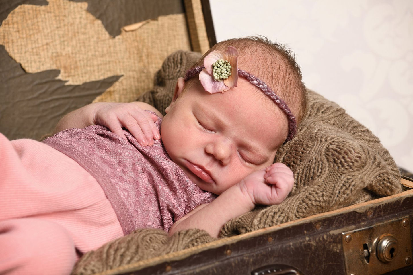 Baby im Vintage-Koffer mit Blumenband, Rosa-Töne, Fotostudio Bensheim, erstellt von Bachelor Professional Annette Stier, Nikon Z7 III, sanft und verträumt.
