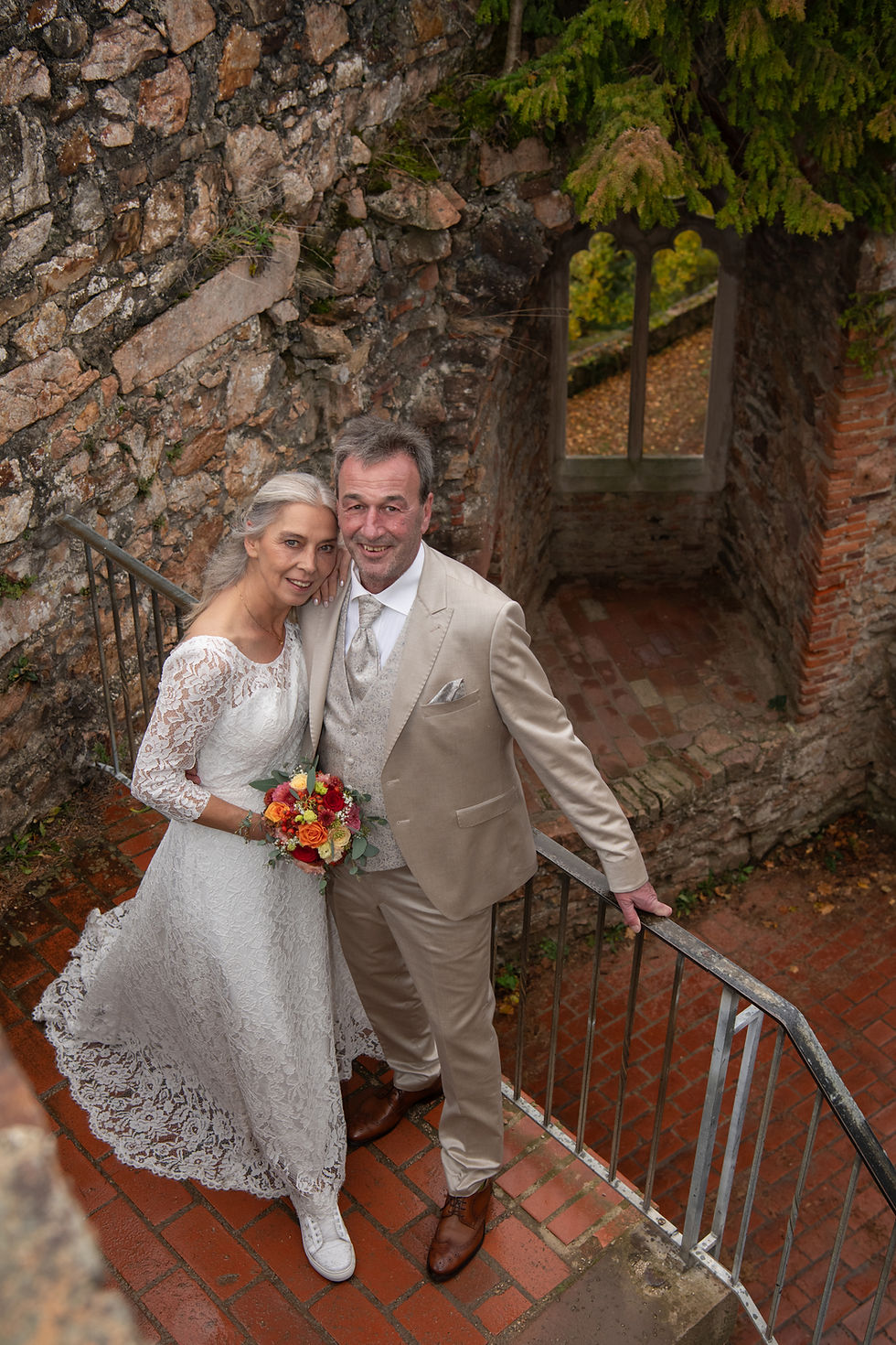 Brautpaar auf Burgtreppe, Braut in Sneakers und Spitzenkleid, Schloss Auerbach.