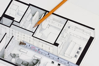 Detailed architectural floor plan drawing with pencil and measuring tape.