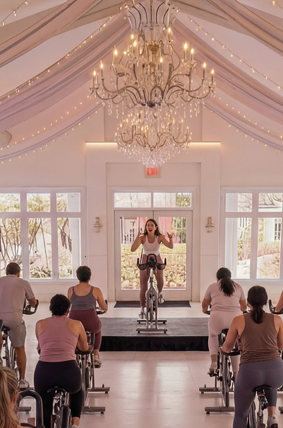 People in spin class with instructor in elegant studio