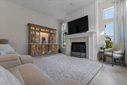 Living room interior with built-in bar, TV, fireplace, and comfortable seating.