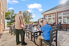 Group of people at outdoor table, interacting, The Grove background.