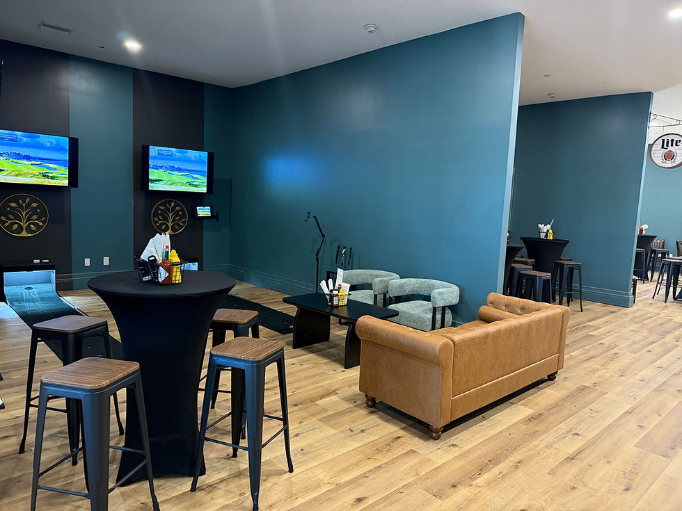 Indoor lounge with golf simulator bays and seating at The Citrus Club at the The Grove event space.