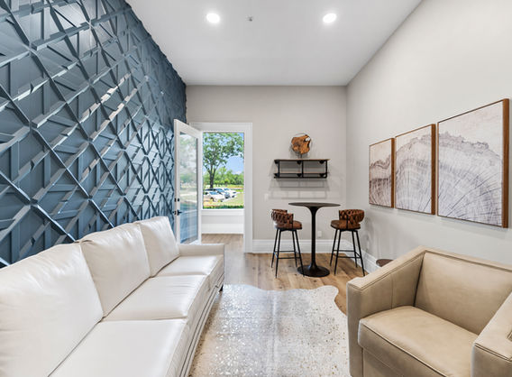 Modern waiting area with white couch and geometric wall design The Grove.