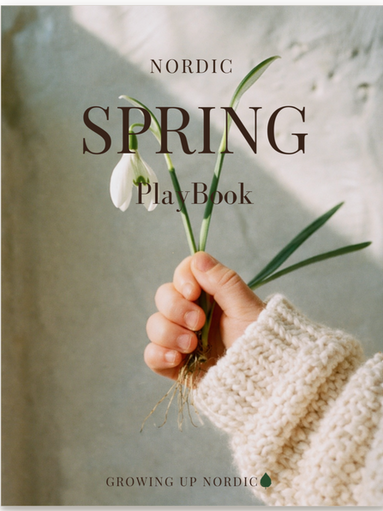 Cover of the Nordic Spring PlayBook, a child's hand holding snowdrops with roots against a pale wall