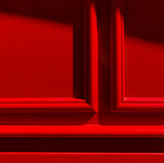 Detalle de puerta roja con paneles y molduras, Color Rojo, iluminación de sol