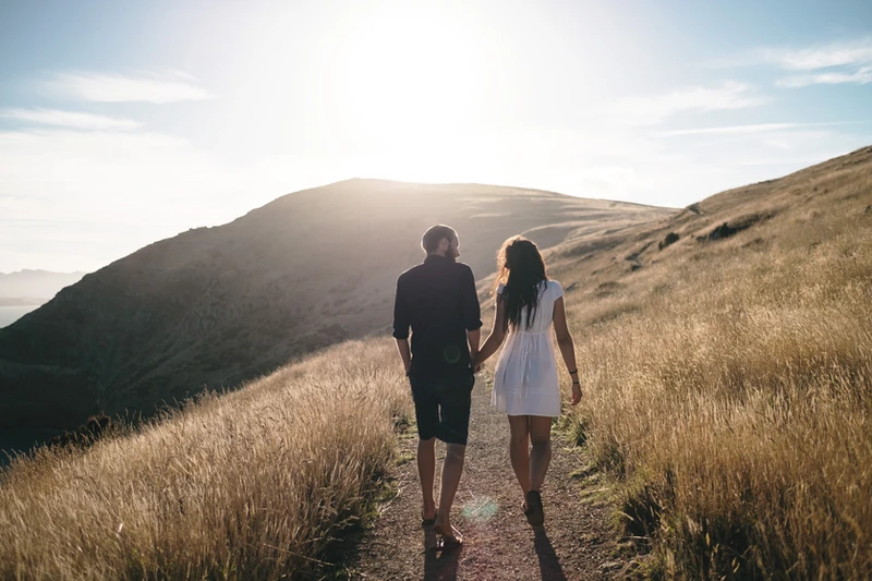 Couple walking hand-in-hand on a scenic path