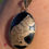 Thumbnail: A vintage egg shaped pendant of black onyx mounted in yellow gold with a yellow gold engraved cat over the front