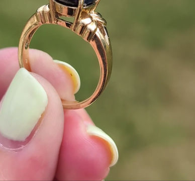 Thumbnail: a large oval facetted black sapphire set into a yellow gold ring
