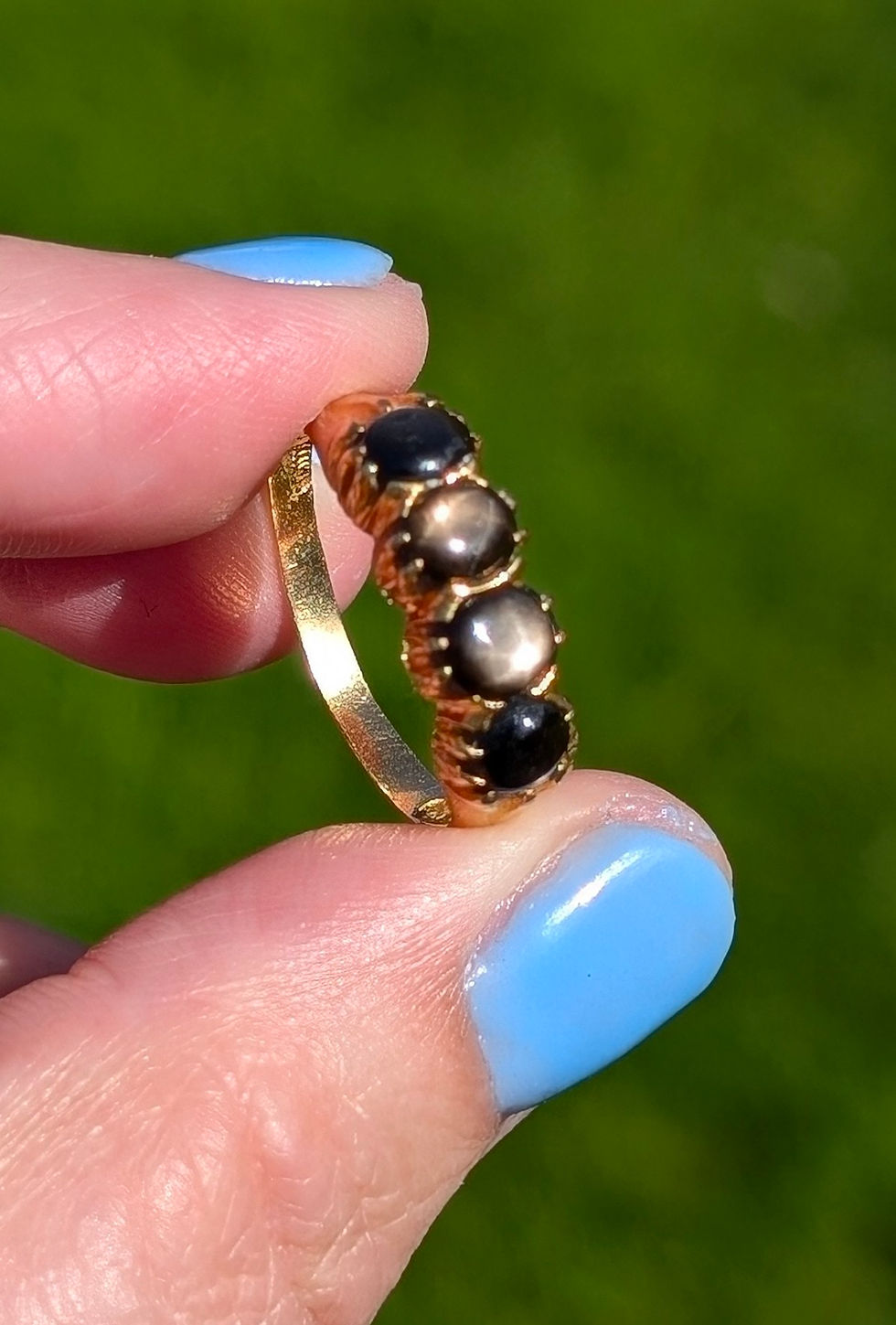 Thumbnail: a antique high carat yellow gold ring set with four round black star sapphires