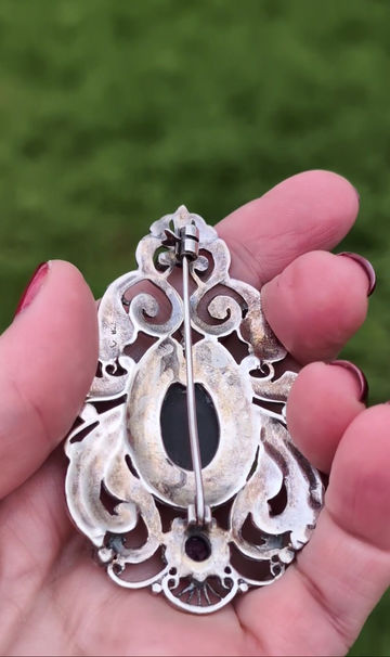 Thumbnail: A large ornate antique silver brooch with black onyx amethyst and marcasite