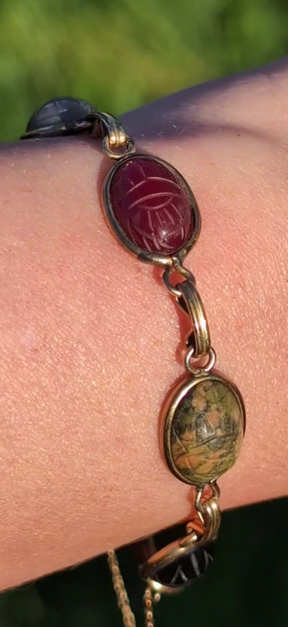 Thumbnail: A vintage yellow gold bracelet with different coloured carved gemstone scarab beetles