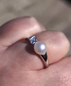 Thumbnail: a white gold modern open ring design with a cultured pearl on one side and a square cut tanzanite on the other