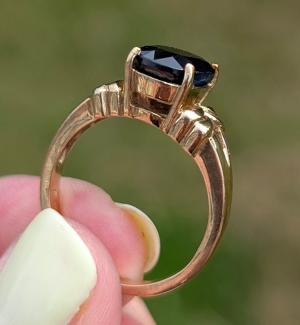 Thumbnail: a large oval facetted black sapphire set into a yellow gold ring