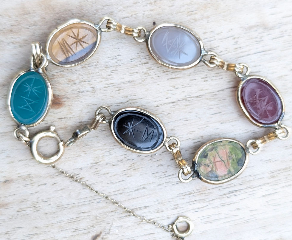 Thumbnail: A vintage yellow gold bracelet with different coloured carved gemstone scarab beetles