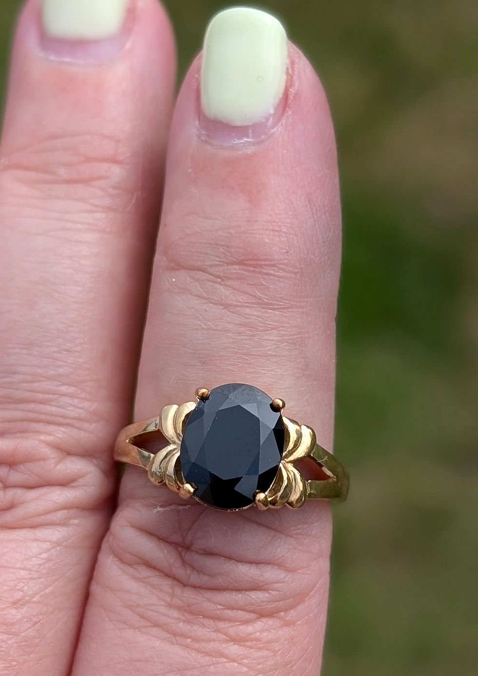 Thumbnail: a large oval facetted black sapphire set into a yellow gold ring