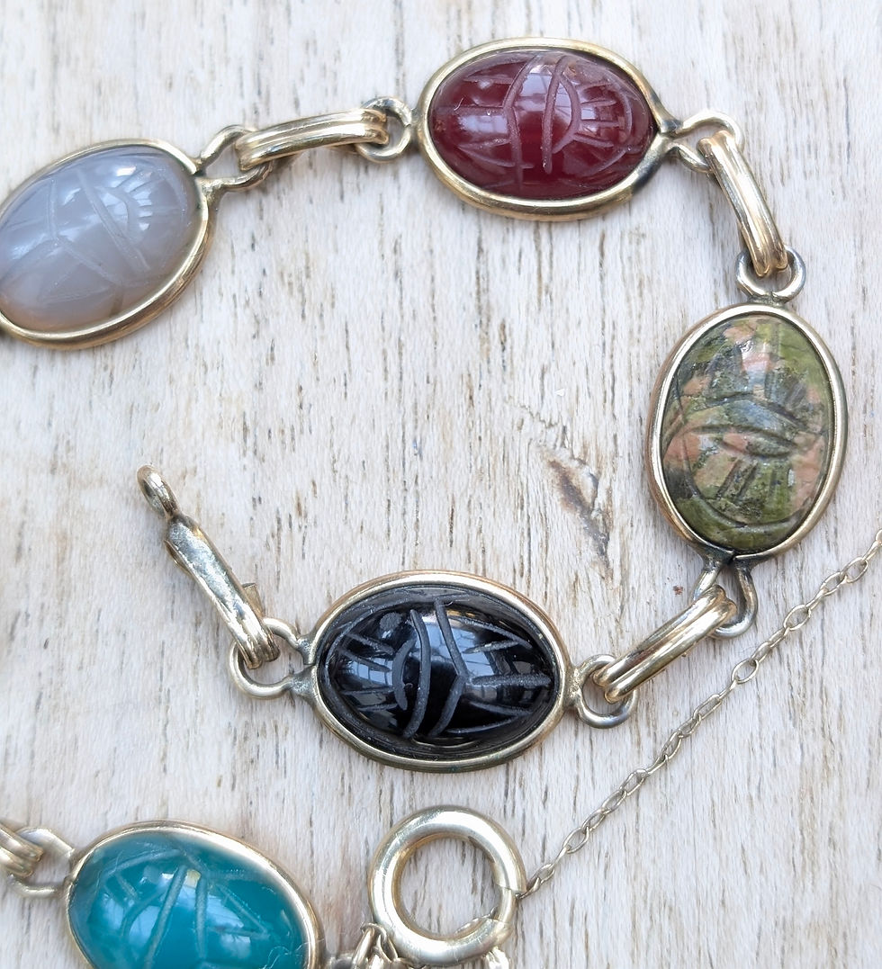 Thumbnail: A vintage yellow gold bracelet with different coloured carved gemstone scarab beetles