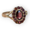 Thumbnail: Antique yellow gold ring with a oval faceted red garnet surrounded by a smaller round halo of red garnets