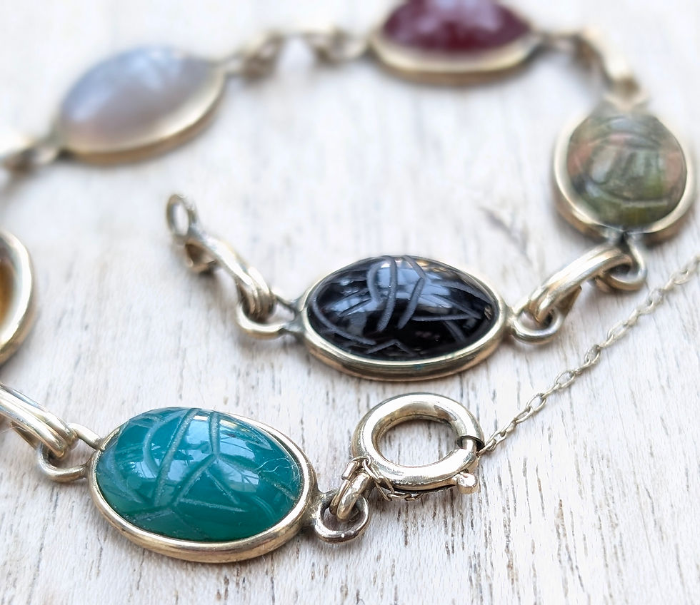 Thumbnail: A vintage yellow gold bracelet with different coloured carved gemstone scarab beetles