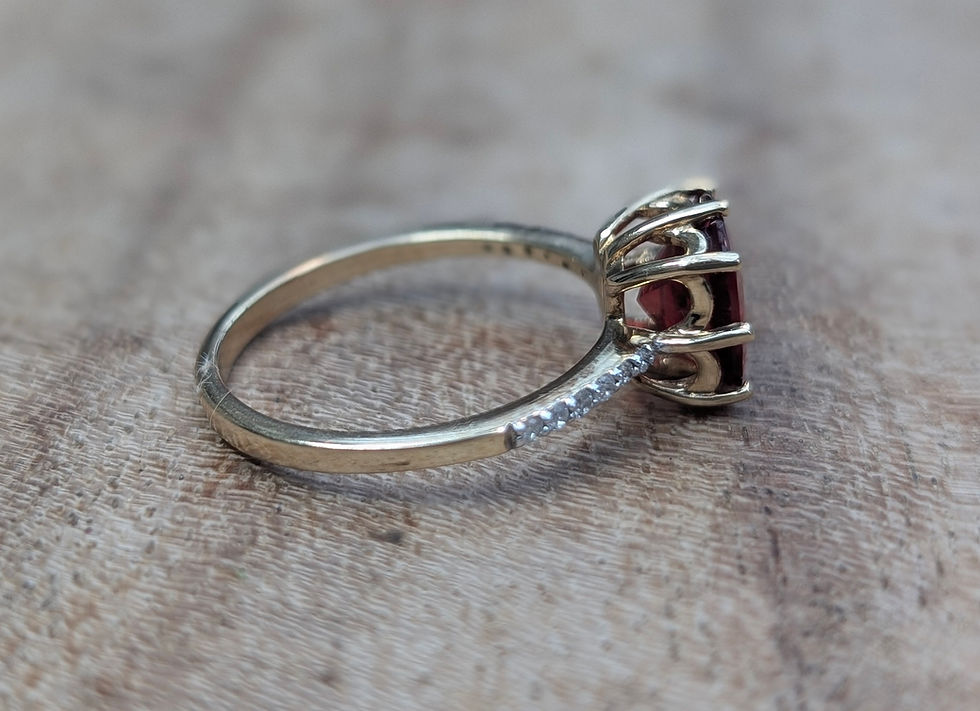 Thumbnail: yellow gold ring set with diamonds and a large cushion cut red andesine gemstone