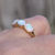 Thumbnail: vintage 14ct yellow gold ring set with three oval cabochons of precious white opal with amazing play of colour