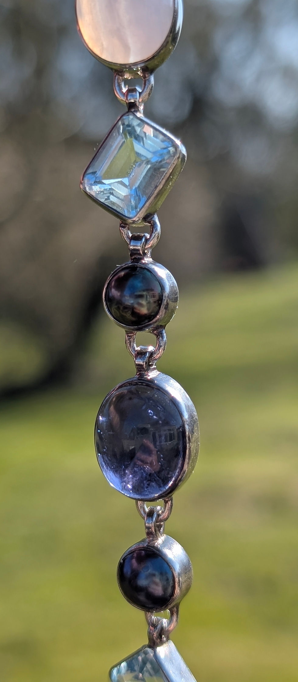 Thumbnail: a articulated silver bracelet set with different blue gemstones