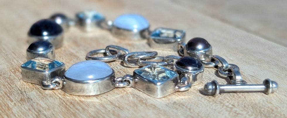 Thumbnail: a articulated silver bracelet set with different blue gemstones