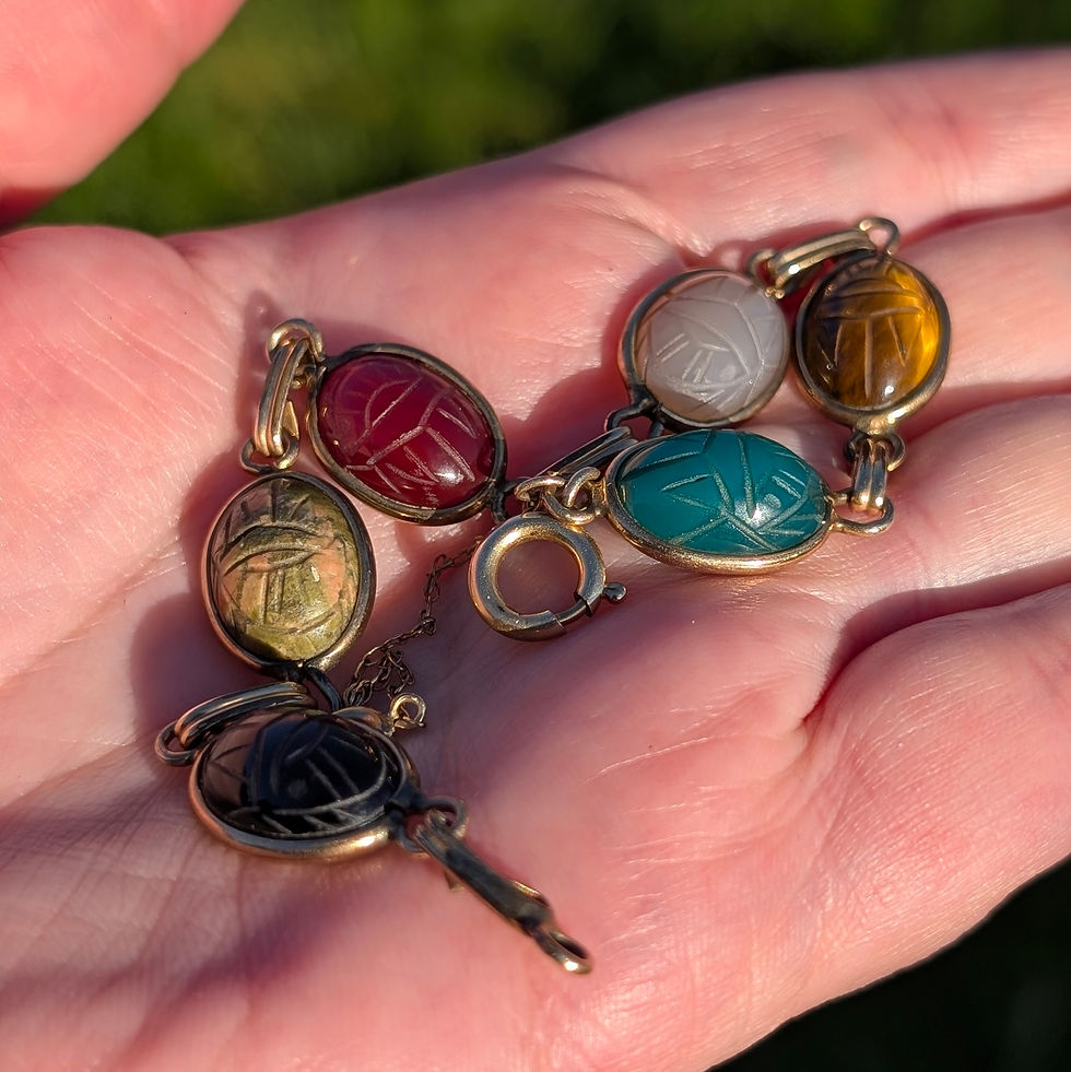 Thumbnail: A vintage yellow gold bracelet with different coloured carved gemstone scarab beetles