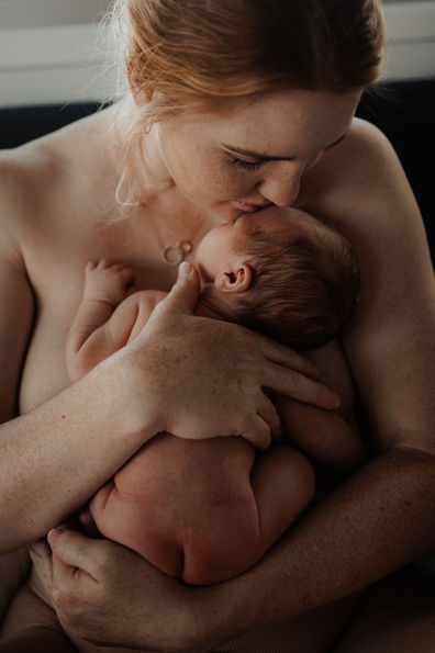 Mother holding and kissing naked baby in Rockhampton newborn photography session