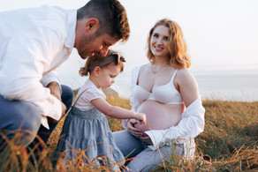 Natural family moment during maternity session on coastal hill in Central QLD