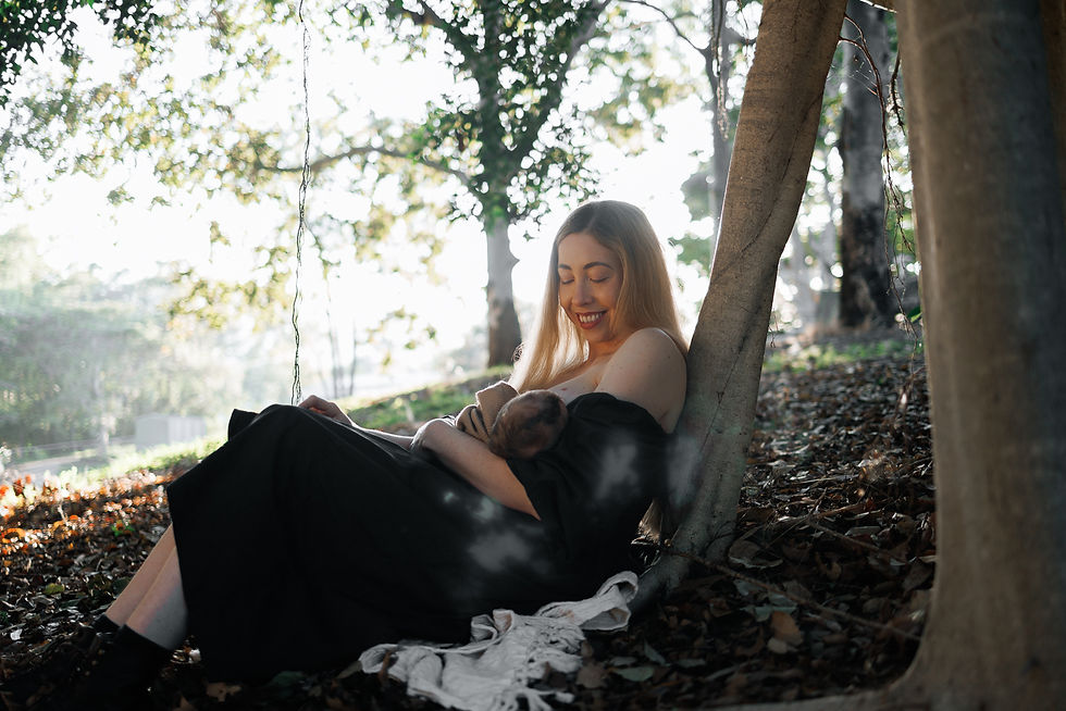 mother breastfeeding under a tree at sunrise during outdoor lifestyle photoshoot with Sarah Joy a Rockhampton newborn photographer