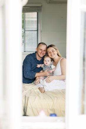 Mum, dad and baby looking out window in Rockhampton