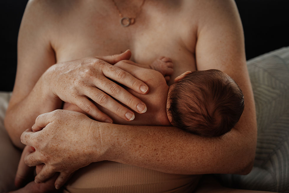 Mother holding her baby whilst breastfeeding during newborn photography session in Rockhampton