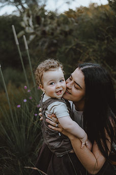 Yeppoon mum kissing her smiling baby boy in outdoor family photoshoot