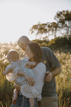 Golden glow sunset photo with family of three looking relaxed 