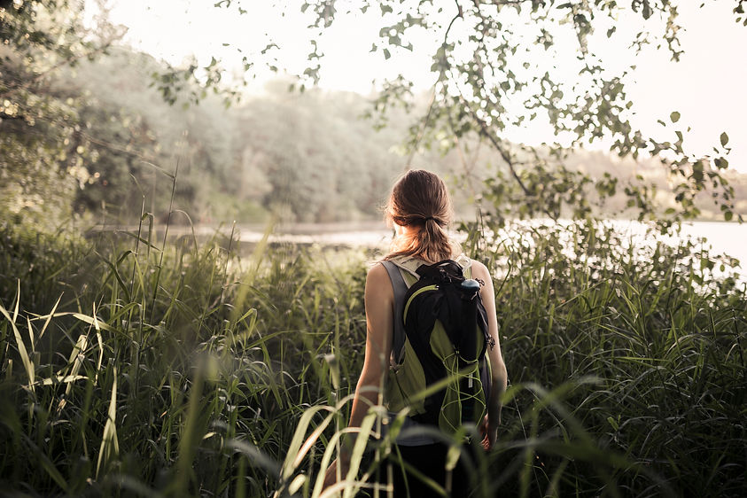 female-hiker-walking-green-grass-near-lake.jpg