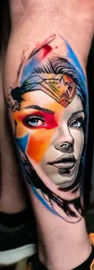 Vibrant and colorful realistic portrait leg tattoo of Wonder Woman with watercolor effects, done at Tattoo Factory Antalya.