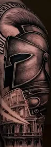 Intricate shoulder tattoo of a Spartan warrior helmet and the Roman Colosseum in black and grey realism, Tattoo Factory Antalya.